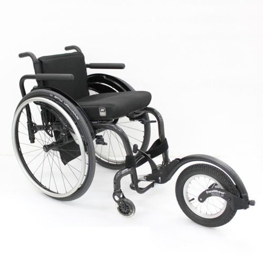 Three-quarter image of a wheelchair with a 'FreeWheel' all-terrain add-on attached to the front via the footrest.