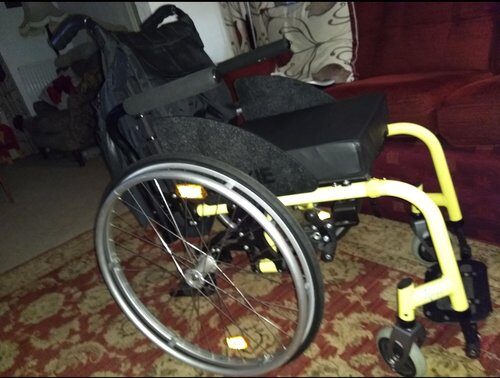 Side profile photo of a 'Quickie Neon' foldable self-propelling wheelchair.