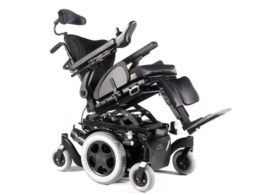 Image of a 'Quickie Salsa M2' electric wheelchair's 'rise and tilt' function in use, rising & tilting the seat back (or forth) as is needed to assist the person using the chair.