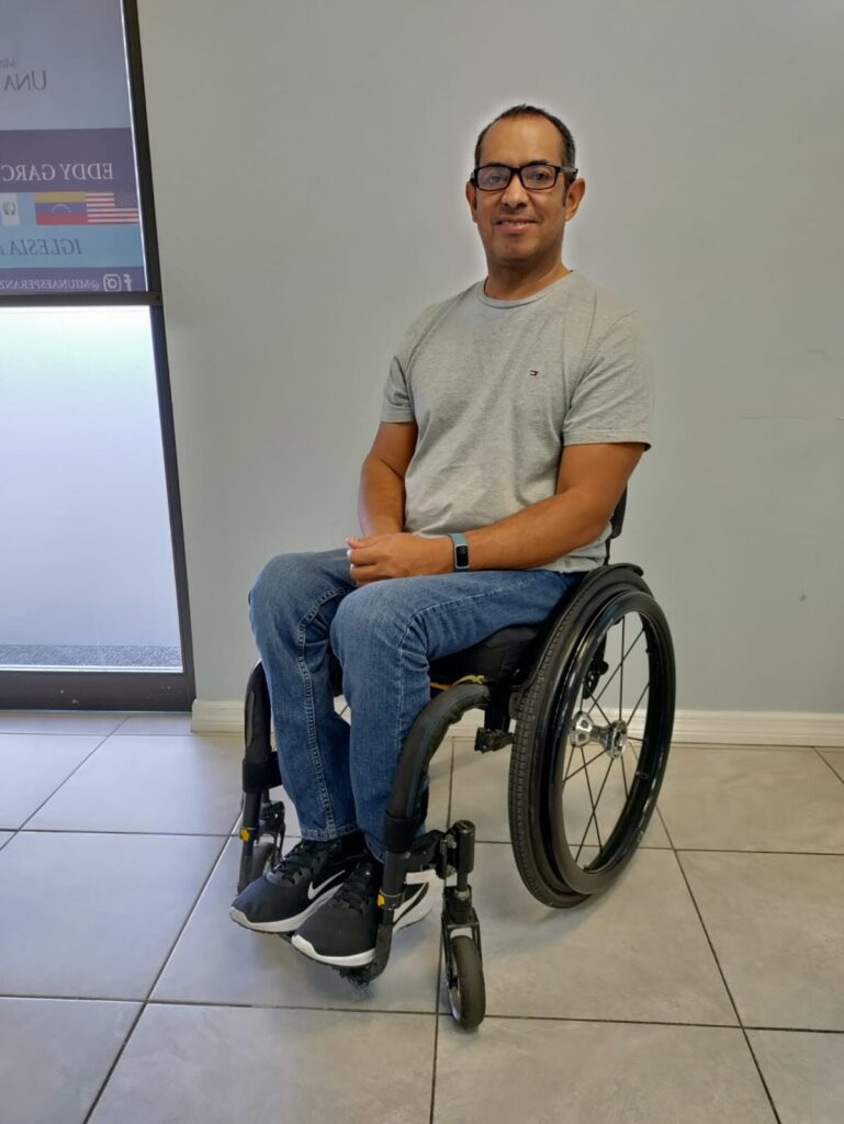 Profile photo of a man posing for a photo while using an 'RGK Tiga' self-propelling wheelchair.